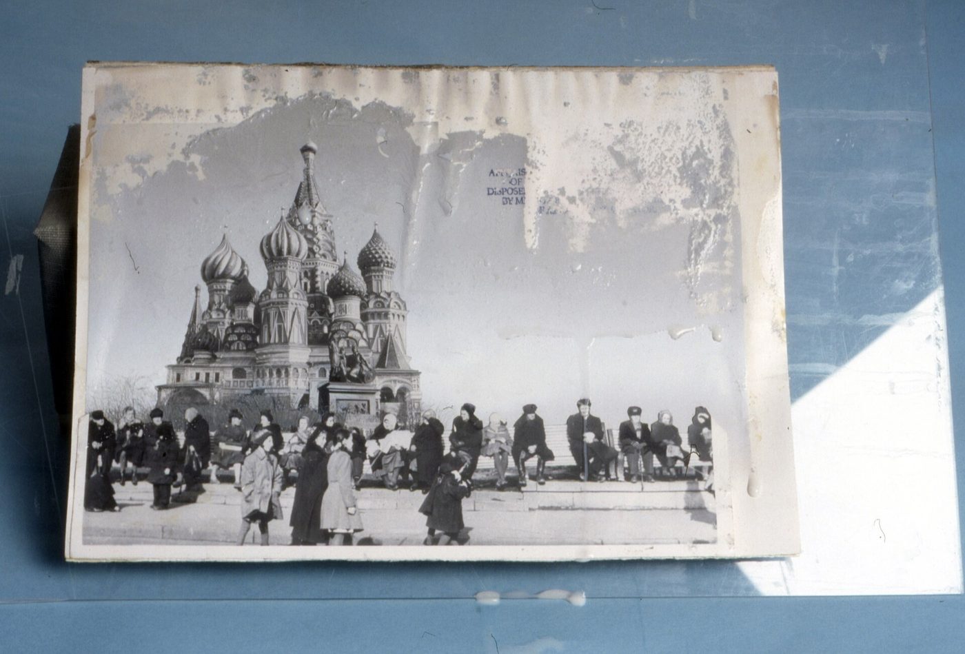 An old black-and-white print of St. Basil's Cathedral with large patches of the image surface lost to water damage