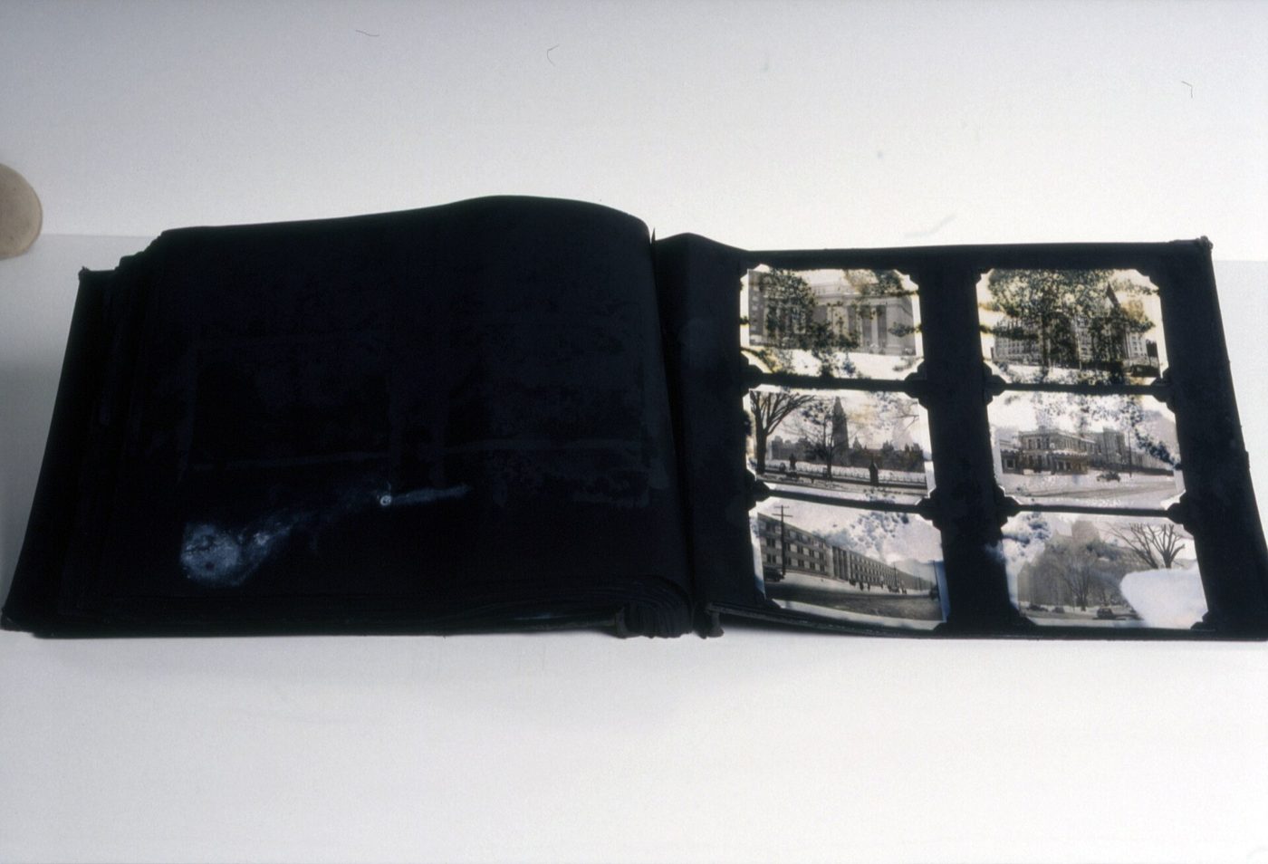 An old photo album with water-damaged, stained and stuck pages